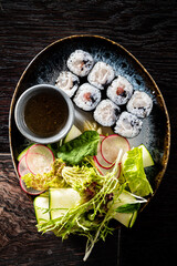 Savoring the Art of Sushi: A Culinary Delight Featuring Delicately Rolled Sushi Paired With Fresh Greens and a Rich Dipping Sauce