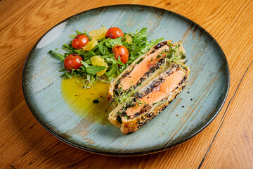 Delightful Salmon Terrine Served With a Fresh Salad and Vibrant Cherry Tomatoes at a Rustic Dining Table During a Cozy Evening Gathering