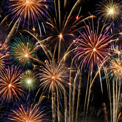 Obraz premium Fireworks Symphony: A dazzling display of fireworks explodes against the backdrop of a starlit night, painting the sky with vibrant colors and intricate patterns.