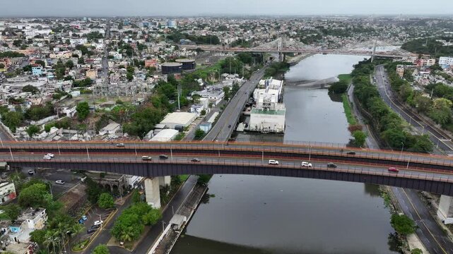 Santo Domingo, Dominican Republic, left panning from R&iacute;o Ozama with Mat&iacute;as Ram&oacute;n Mella and Puente Juan Pablo Duarte Bridge across Ciudad Colonial , 4k aerial video footage
