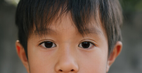 Close up little Asian  boy's eye with looking straight to the target. Healthy life concept.