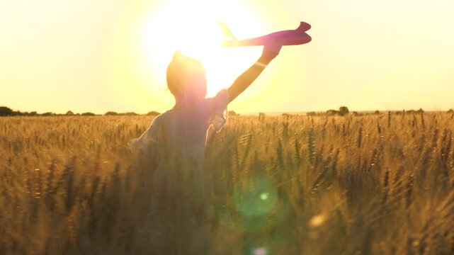 little child girl kid daughter runs through wheat field with toy plane her hand sunset, happy family dream fly, teenager plays with toy plane, child dreams becoming airplane pilot, plays with toy