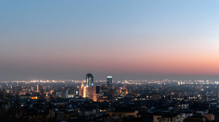 Obraz premium City view at dusk. Night lights illuminate buildings as the sun sets. Use for travel brochures or city guides