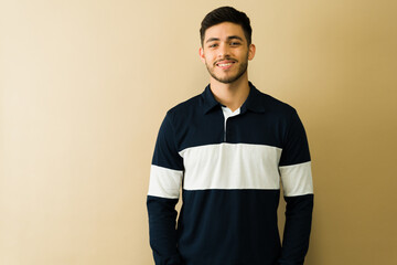 Fototapeta premium Portrait of a smiling young man posing with hands in pockets