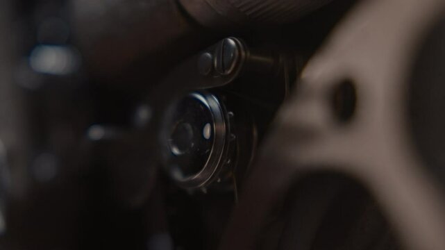 Close ups of a vintage 8MM projector spools moving and playing film 