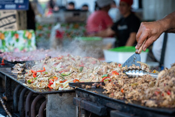 Puesto de comida callejera en Argentina, carnes y verduras salteadas a la plancha