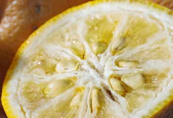 Brightly colored yuzu lemon cut in half showcases its delicate, juicy interior with a focus on...
