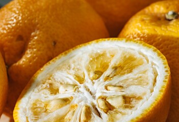 In a warm kitchen illuminated by sunlight, fresh yuzu lemons sit together, showcasing their unique texture and vibrant hue. Their delightful aroma promises a burst of flavor in recipes