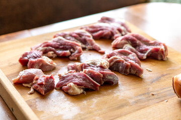 Pieces of raw meat on a wooden board. Food concept