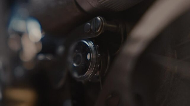Close ups of a vintage 8MM projector spools moving and playing film 