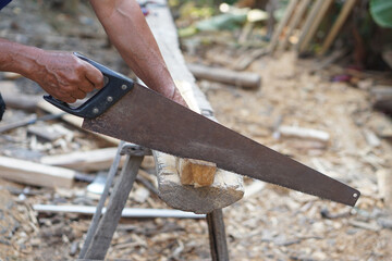 Close up carpenter hand is cutting wood by saw. Concept, tool for cutting. Carpentry , woodwork and...