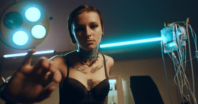 Sexy lady dancing in operation room, hallucination by anesthesia, slow motion. Beautiful young woman with tattoos and piercings moving slowly, alternative style of appearance, sensual female person
