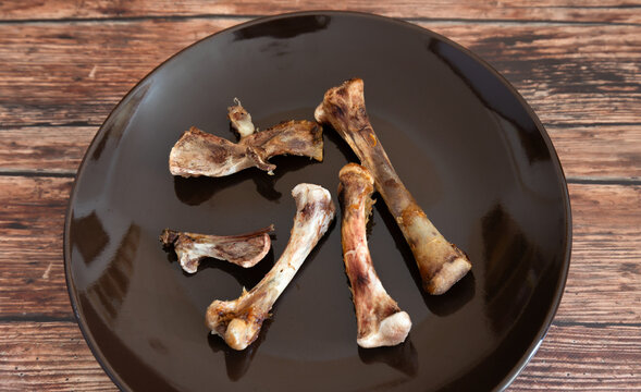Chicken thight bones on a plate. Food waste background.