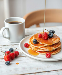 Delicious stack of pancakes topped with fresh berries and syrup on a charming breakfast table
