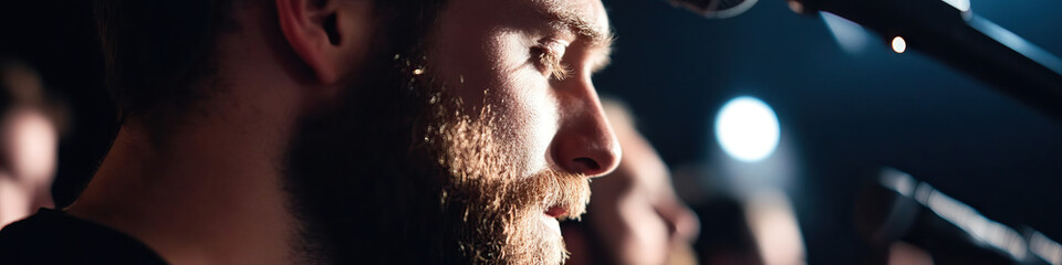 Naklejka premium Close-up of Bearded Man's Profile with Microphone