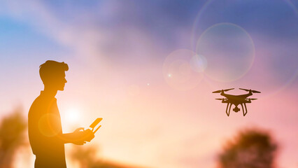 A silhouette man playing with drone
