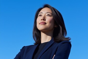 Happy confident young Asian professional woman, female entrepreneur, businesswoman staring  into the sky dreaming of future success.