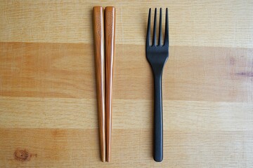 Chopsticks and fork side by side in a culinary presentation modern kitchen still life photography natural lighting artistic perspective emphasizing dining utensils