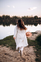 young woman standing on the shore of the river