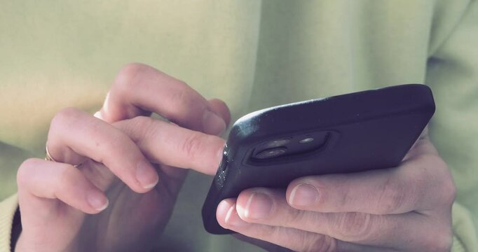 young woman at home working remotely using phone to edit video