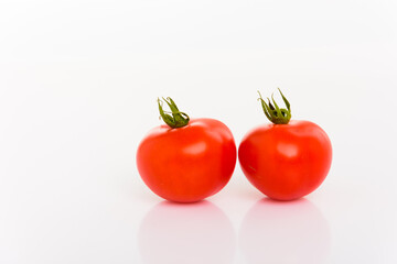 Zwei frische rote Tomaten mit Stengeln vor weißem Hintergrund isoliert
