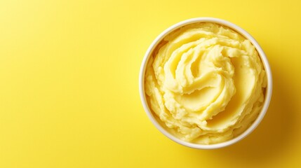 Potato puree in bowl, yellow background, top view