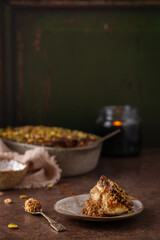 A piece of Dubai chocolate tiramisu with pistachio and chocolate ganache with candle. Italian tiramisu dessert with layers of lady finger biscuit and mascarpone. Professional food photography. 