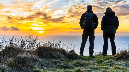 Fototapeta premium Couple Watching Sunset Over Ocean