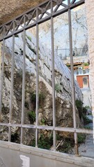 In the photograph, a huge stone is visible through the metal grating.