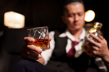Businessman sitting Holding a Glass of Whiskey Drink drinking whiskey 