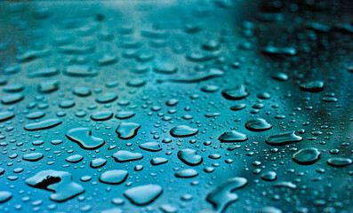 Un jour de pluie - Gouttes d'eau sur une vitre avec une teinte turquoise