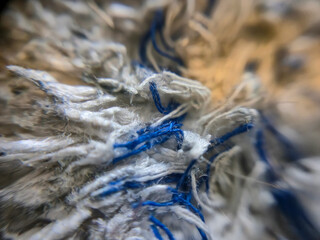Close-up of textured fabric showcasing intricate fibers in blue and white, perfect for design...