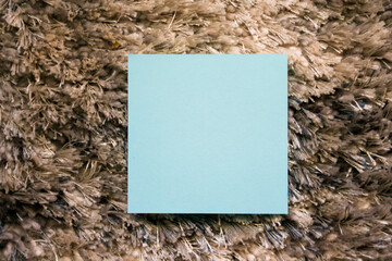 A blue square note rests on a textured surface, creating an engaging contrast. Ideal for creative...
