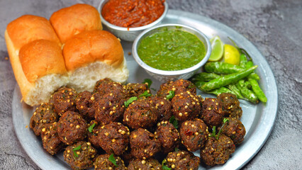 Meat balls, Kebab on a silver plate with soft buns, vibrant red and green sauce, and crispy fried...