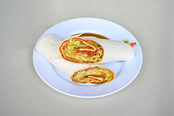 Cig kofte (raw meatball) with lettuce, tomato, pickle and lemon, hot Chee kofta. Turkish local raw food concept.Table scene of assorted take out or delivery foods. Doritoslu duble cig kofte durum.