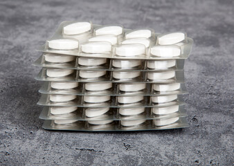 Medical pills in blister pack on grey background.
