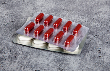 Medical pills in blister pack on grey background.