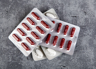 Medical pills in blister pack on grey background.