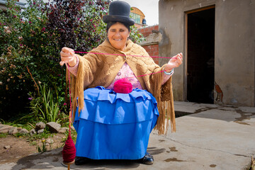 old woman cholita aymara woman in pollera working with wool in the yard of her house in the city of la paz bolivia - concept of handicraft work