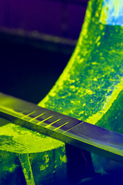 Quality Control Test Block for Magnetic Particle Inspection. Fluorescent green MPI reference standard with defects under ultraviolet illumination