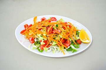 Green salad with arugula, lamb and tomatoes. Healthy vegan dish. Top view at table. Turkish Coban (choban) salata or Shepherds salad, Akdeniz salad in white bowl.