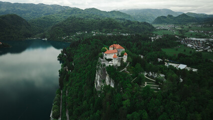 Aerial view of Church of the Assumption of Mary in the center of the lake Bled. Flying around small...