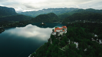 Aerial view of Church of the Assumption of Mary in the center of the lake Bled. Flying around small...