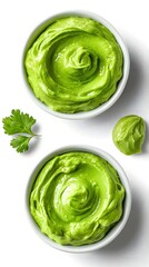Obraz premium Vibrant avocado dip in white bowl with fresh cilantro garnish on a clean white surface