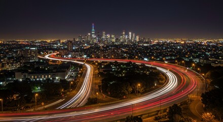 Fototapeta premium Nightfall Cityscape with Highway: A breathtaking panoramic view of a vibrant city skyline at night, with a winding highway's light trails creating dynamic streaks across the landscape.