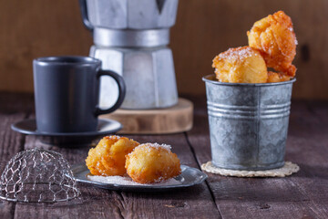 Curd donuts with sugar served with tea or coffee on a light wooden background. Rustic style.