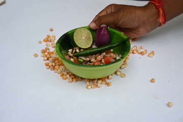 Grilled corn Chaat. Indian style corn salad that's sweet, spicy and tangy. It is mixed with chaat masala, roasted cumin powder, red chili powder, coriander leaves, onion and tomatoes. Indian snacks.