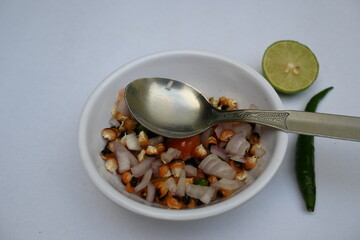 Grilled corn Chaat. Indian style corn salad that's sweet, spicy and tangy. It is mixed with chaat masala, roasted cumin powder, red chili powder, coriander leaves, onion and tomatoes. Indian snacks.
