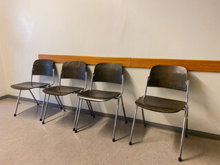 Four Wooden Chairs in a Quiet Government Building Hallway – Waiting Area Scene