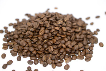 some roasted coffee beans placing on a white paper